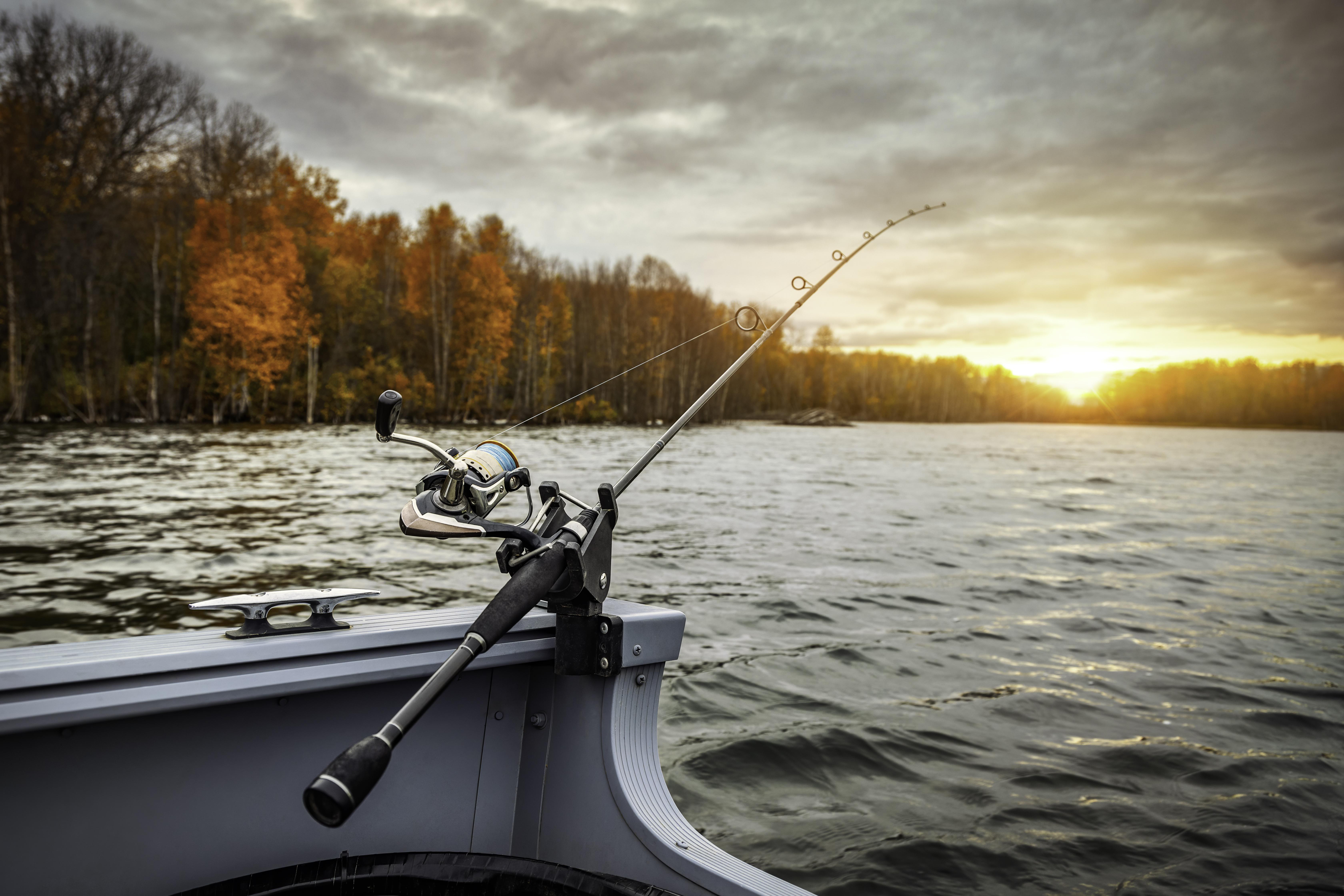 Fishing rod and reel on a boat at sunset